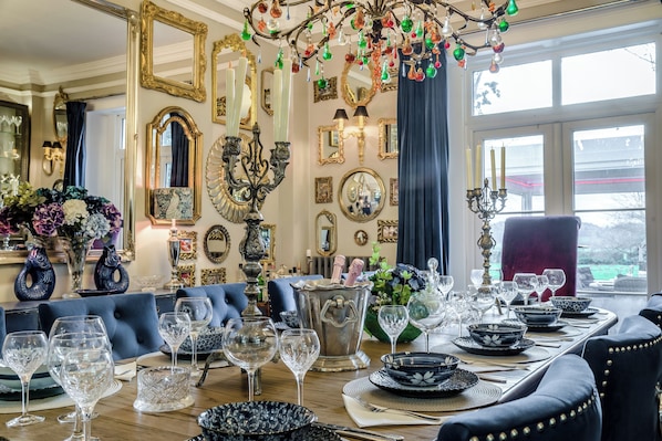Ein Esszimmer mit einem für sechs Personen gedeckten Tisch, umgeben von blau gepolsterten Stühlen.
