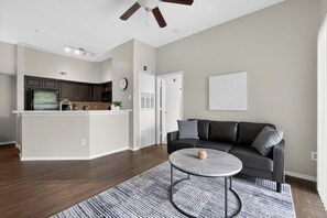 Una cucina moderna con mobili scuri, un'isola bianca e una ventola a soffitto.