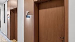 Un pasillo con puertas de madera, cada una con un número y una cerradura.