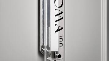 A clear, cylindrical object with the text 'NOOMA inn' on it, mounted on a wall.