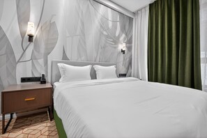 Une chambre d’hôtel moderne avec un grand lit, une table de chevet, une lampe fixée au mur et un rideau vert.