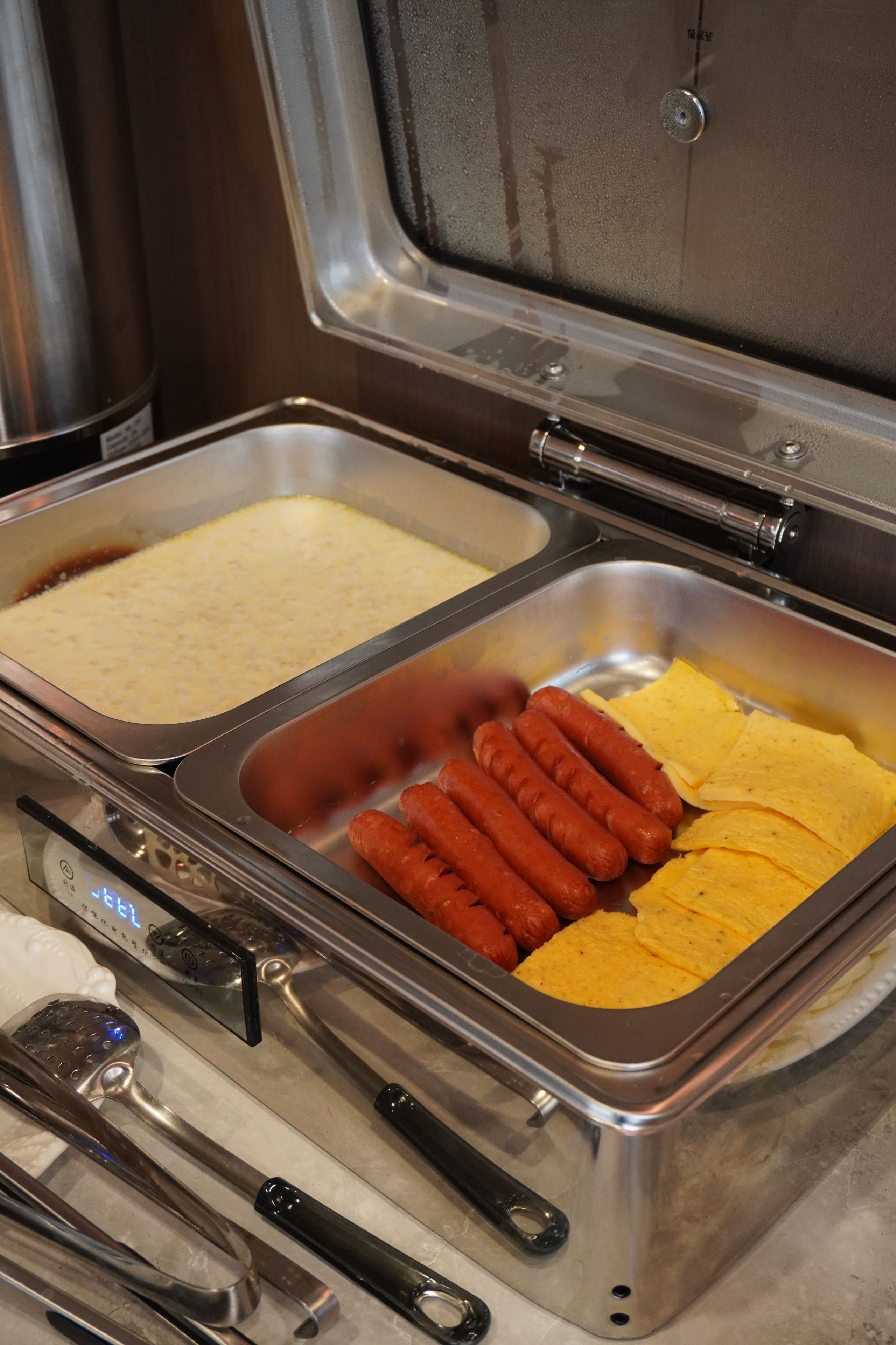 A buffet with hot dogs, cheese, and chips.