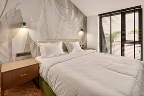 Une chambre à coucher moderne, avec un lit, des tables de chevet, des appliques murales et une fenêtre équipée de stores.