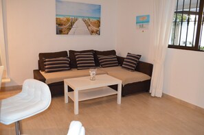 Ein modernes Wohnzimmer mit einer Couch, einem weißen Couchtisch und einem Sessel.