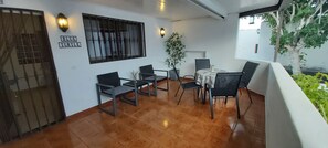 Uma área de refeições com uma mesa e cadeiras, uma planta em vaso e uma placa com a inscrição 'BLUE TURTLE'.