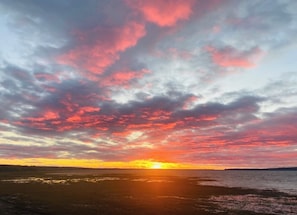 A sunset over a body of water with a beach in the foreground. - Country House: Charm, Authenticity, Tranquility (Saint-Antoine-de-Tilly)