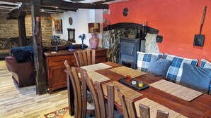 Ein gemütlicher Essbereich mit Holztisch, Stühlen und einer roten Wand.