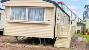 A mobile home with two windows, a number '50' on the side, and a small porch area. - 3 Bed Caravan - Sleeps 8 - Free Parking (Skegness)