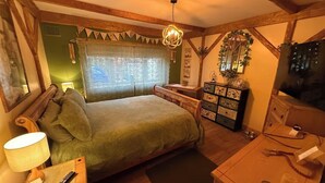 Ein Schlafzimmer mit Bett, Kommode, Schminktisch und Fernseher.
