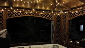 Ein Whirlpool unter einem hölzernen Pavillon mit Lichterketten.