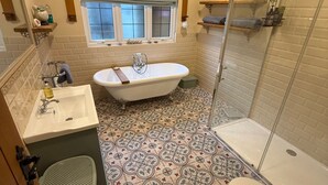 Ein Badezimmer mit einer freistehenden Badewanne, Toilette, Waschbecken und Duschkabine.
