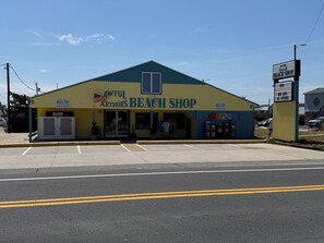 A beach shop with a blue and yellow exterior, an American flag, and a sign indicating it is open. - BRAND NEW Luxury Semi-Oceanfront in Kill Devil Hills Seaduction (Kill Devil Hills)