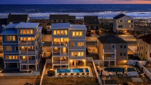 A beachfront residential area with multi-story buildings, a swimming pool, and a view of the ocean. - BRAND NEW Luxury Semi-Oceanfront in Kill Devil Hills DevOcean (Kill Devil Hills)