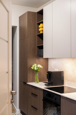 Una cocina moderna con armarios de madera, encimera de mármol y una máquina de café.