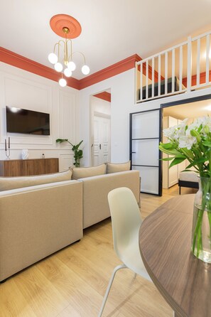Un espacio de estar moderno con sofá, mesa de comedor y área de cocina.
