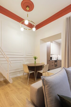 A modern interior with a dining area, kitchen, and staircase. - Native Apartments Węgierska 10  (Kraków)
