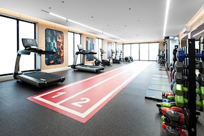 Academia com esteiras, elípticos e equipamentos de musculação.