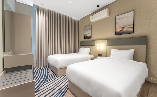Quarto de hotel com duas camas, um espelho grande, um aparelho de ar condicionado e um quadro na parede.