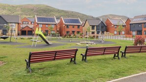 A residential area with houses, a playground, and benches. - Beacon View (Malvern)