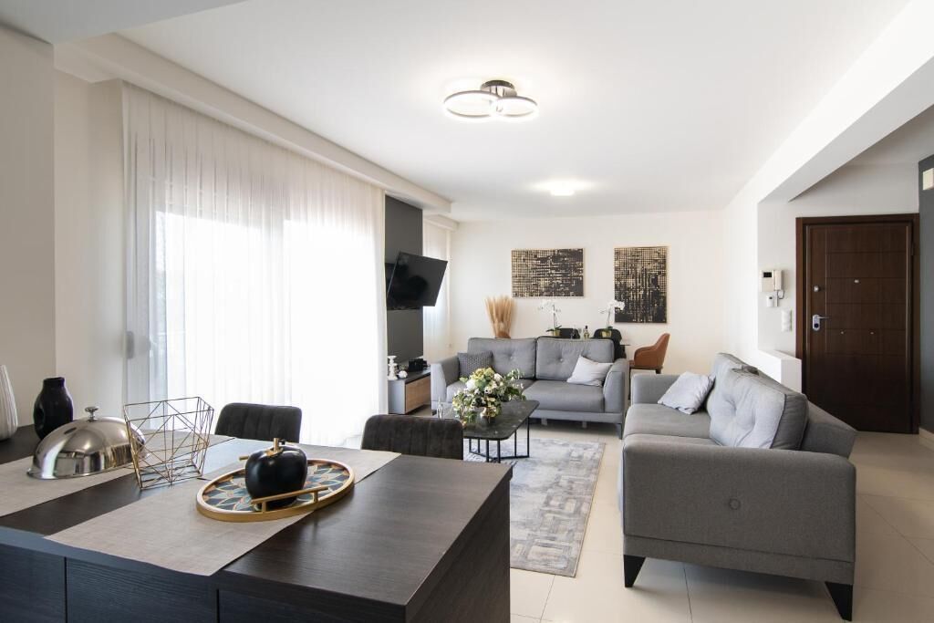 A modern living room with a sofa, coffee table, and dining area.