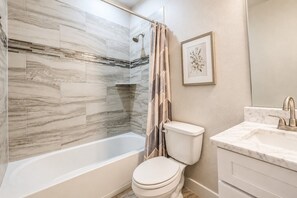 A bathroom with a bathtub, toilet, and sink. - House FIFA 2026 Ready | 9 min to NRG Stadium (Houston)