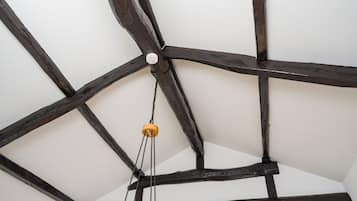 A ceiling with exposed wooden beams and a hanging light fixture.