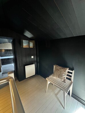 Ein Zimmer mit einer weißen Bank, einem Heizkörper und einer dunklen Wand.
