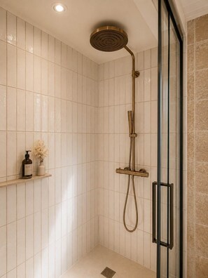 A shower with a gold showerhead, a handheld showerhead, and a glass-enclosed shower stall. - Fleur de Sel Room with Private Bathroom (LE BOIS PLAGE EN RE)