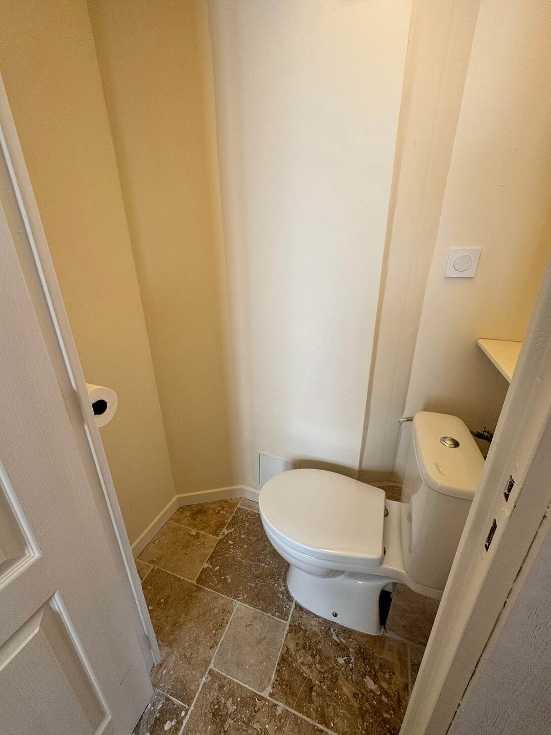 Et lille badeværelse med toilet, bruseniche og håndvask.