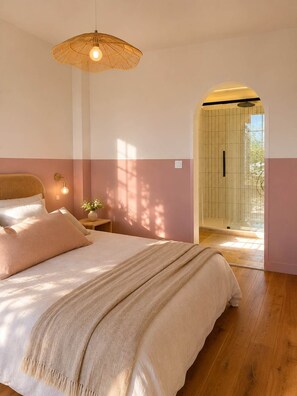 A bedroom with a bed, bedside lamps, a hanging light fixture, and a view of an outdoor area. - Fleur de Sel Room with Private Bathroom (LE BOIS PLAGE EN RE)