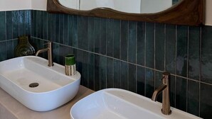 A bathroom with two sinks, a large mirror, and wall-mounted sconces. - Criste Marine Deluxe Suite (LE BOIS PLAGE EN RE)