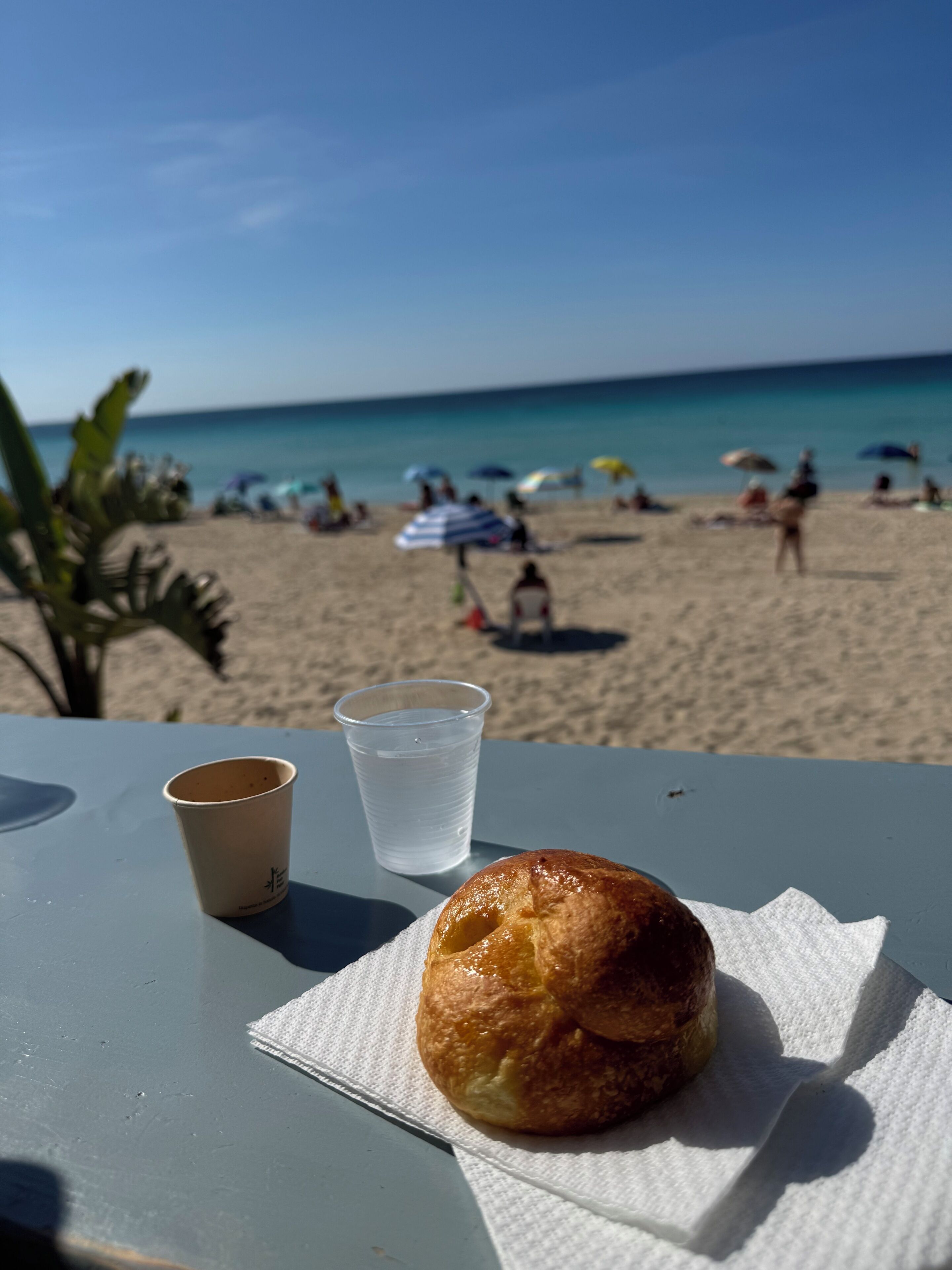Une table avec une pâtisserie, un gobelet en papier et un gobelet en plastique.