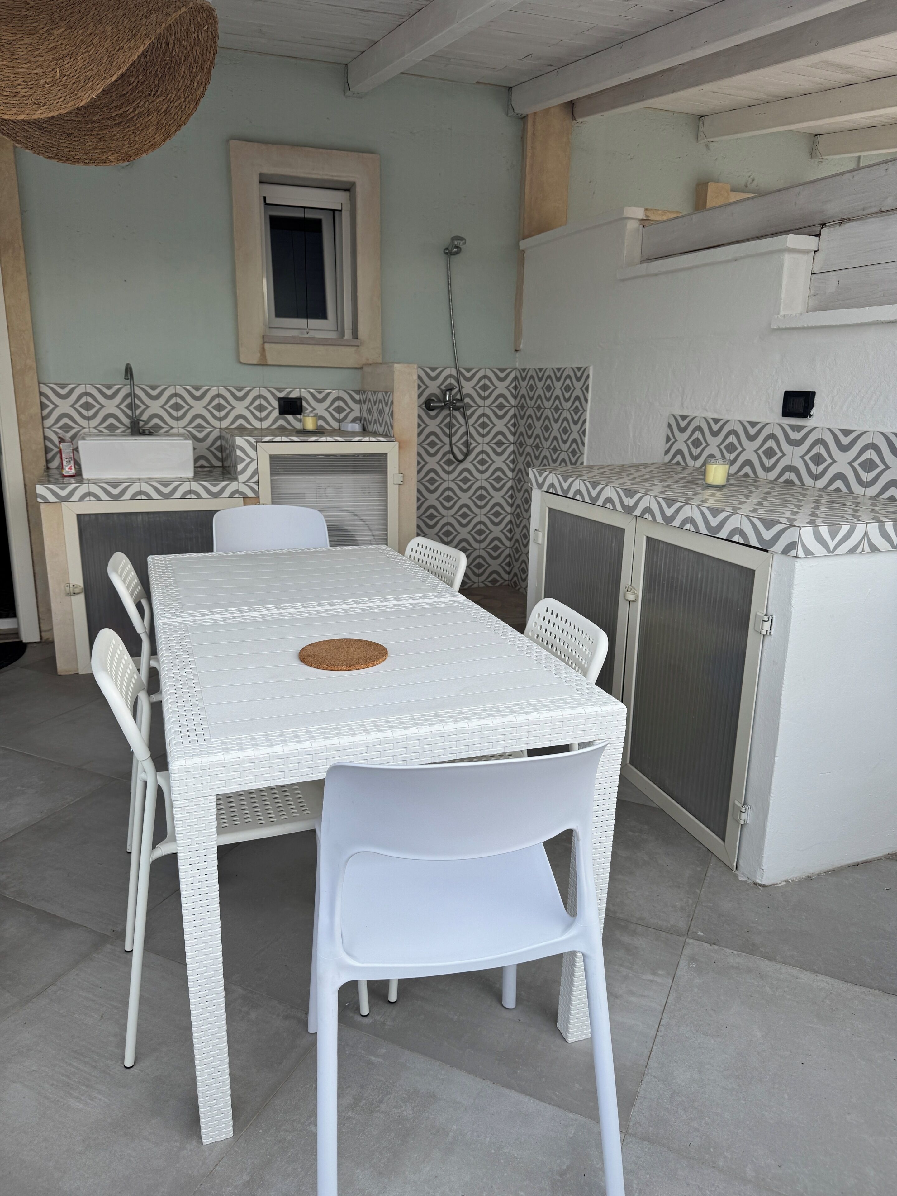 A kitchen with a sink, a window, and a patterned backsplash.