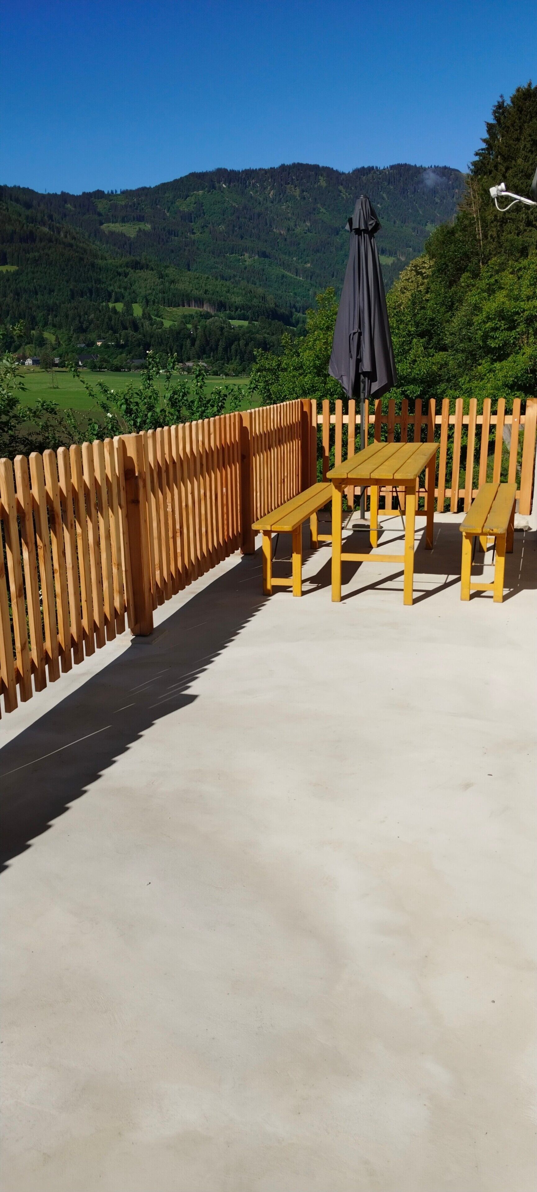A wooden deck with a table and benches, overlooking a green valley and mountains.. Holiday Home 'Ferienhaus Sonnseitn' with Mountain View, Private Terrace and Private Garden