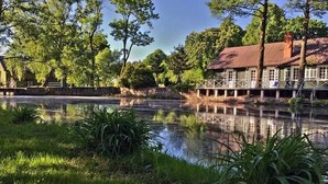 A lakeside building with a dock, surrounded by trees and a calm water body. - Scenic Riverside House with Beautiful Views (Litwinki)