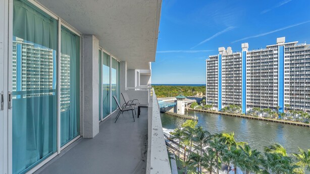 Ein Balkon mit Blick auf ein Gewässer und ein Hochhaus.