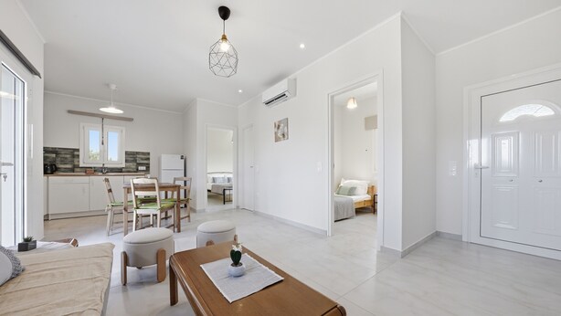 A modern apartment with a dining area, kitchen, and living space.