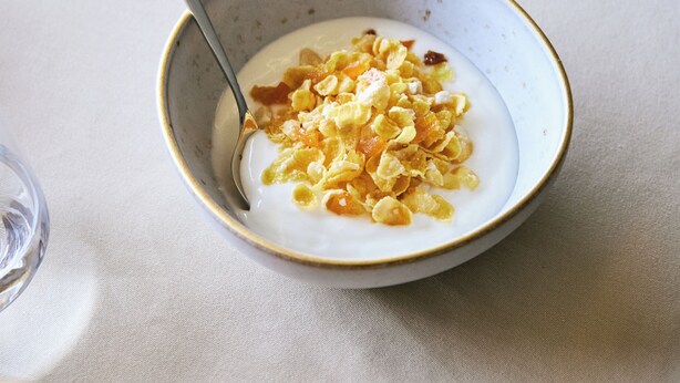 Eine Schüssel Joghurt mit Granola auf einem Tisch.