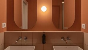 A bathroom with two sinks, a mirror, and a light fixture. - Casa Nido Diagonal (Barcelona)