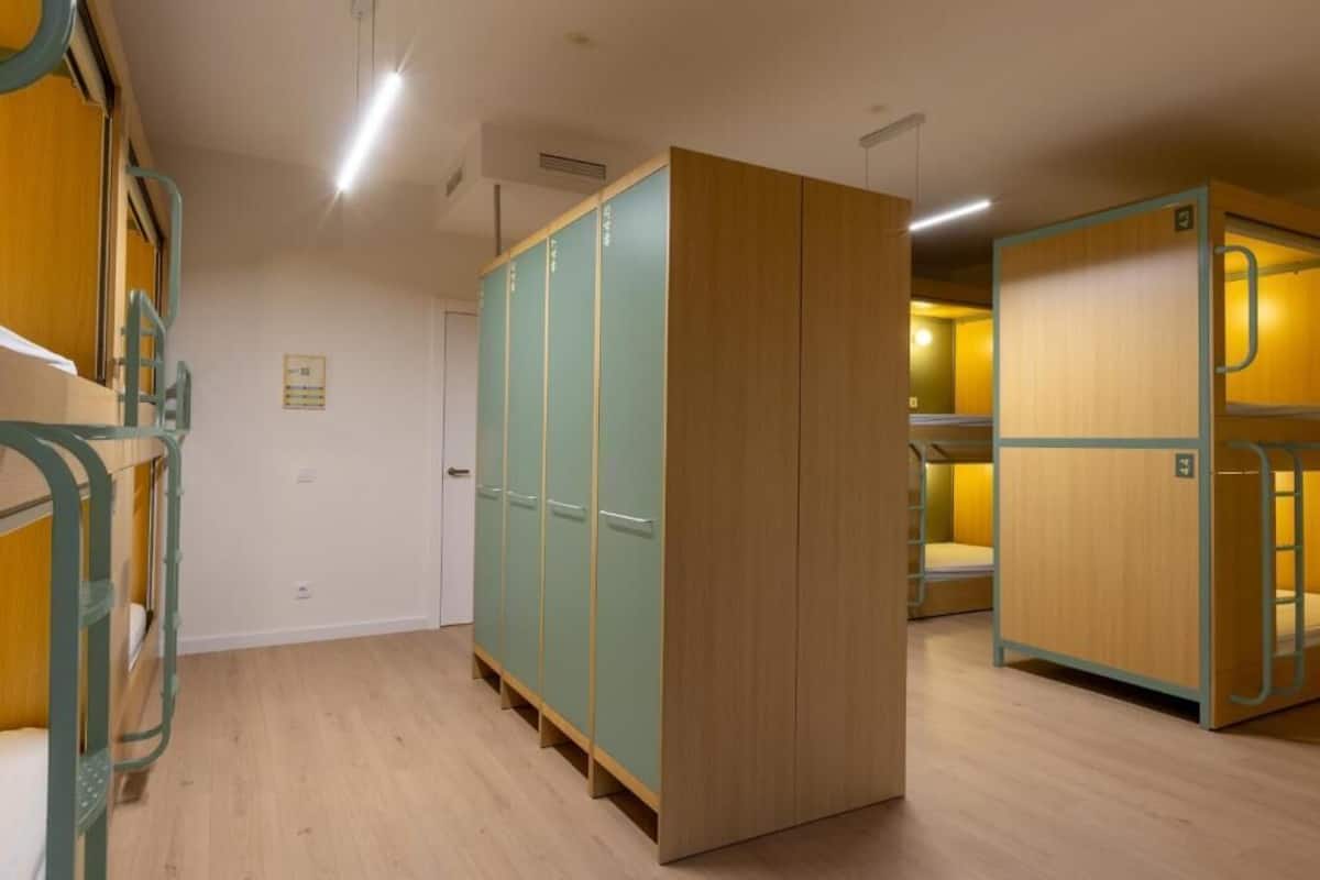 Un dormitorio con literas, un armario y una puerta.