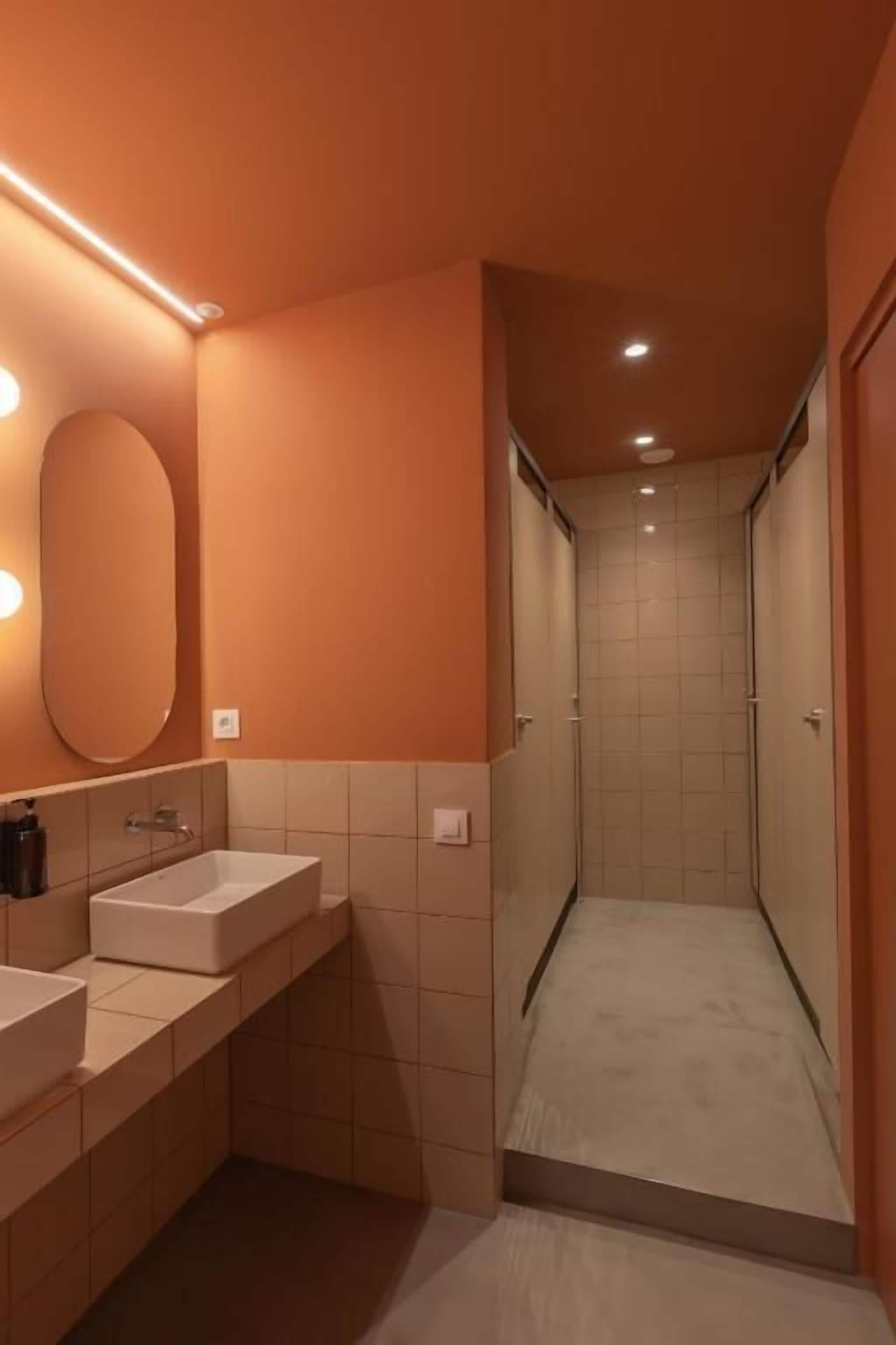 Une salle de bain avec deux éviers, un miroir et un espace douche.