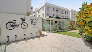 A building with a bicycle mural, a reception area, and a water sports academy sign. - B-Rent Bristol Beach Surf & Fun – Your Perfect Fuerteventura Getaway (Corralejo)