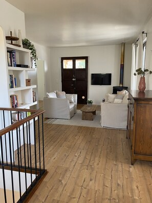 A living room with a sofa set, a coffee table, a bookshelf, a TV, and a fireplace. - Cozy family villa in Provence with a large terrace, pool, and village life right nearby. (Cotignac)
