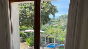 Ein Zimmer mit einer Schiebetür zu einem Außenbereich mit Pool und Garten.