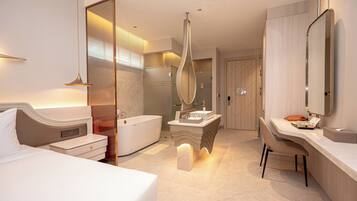 Une chambre d’hôtel moderne équipée d’un lit, d’une baignoire, d’une coiffeuse avec un miroir et d’un bureau.