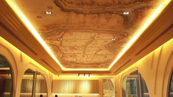 Un restaurant doté d’un plafond au design original, d’un espace repas et d’un comptoir.