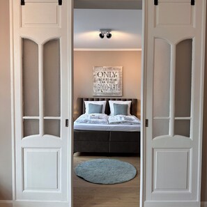 Ein Schlafzimmer mit Bett, Teppich und einem motivierenden Zitat an der Wand.