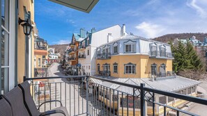 Ein Balkon mit Blick auf eine Stadt, darunter Gebäude und ein Restaurant.
