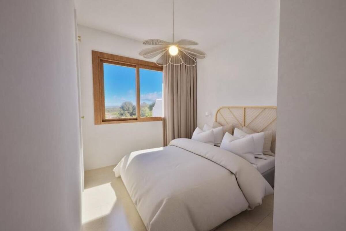 Un dormitorio con cama, ventana y ventilador de techo.
