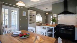 Une cuisine équipée d’une cuisinière, d’un four et d’une table à manger avec des chaises.